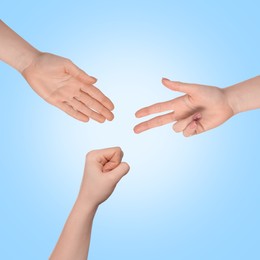 People playing rock, paper and scissors on light blue background, top view