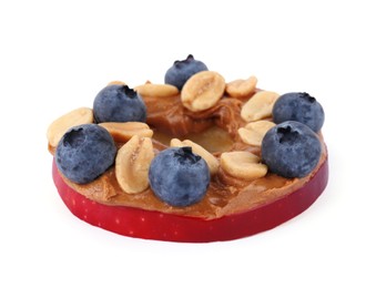 Photo of Slice of fresh apple with peanut butter, blueberries and nuts isolated on white