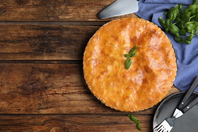 Delicious pie with meat and basil on wooden table, flat lay. Space for text