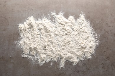 Photo of Scattered flour on grey textured table, top view