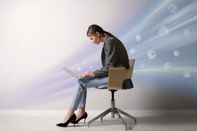 Image of Speed internet. Woman using laptop in chair near light grey wall. Motion blur effect symbolizing fast connection
