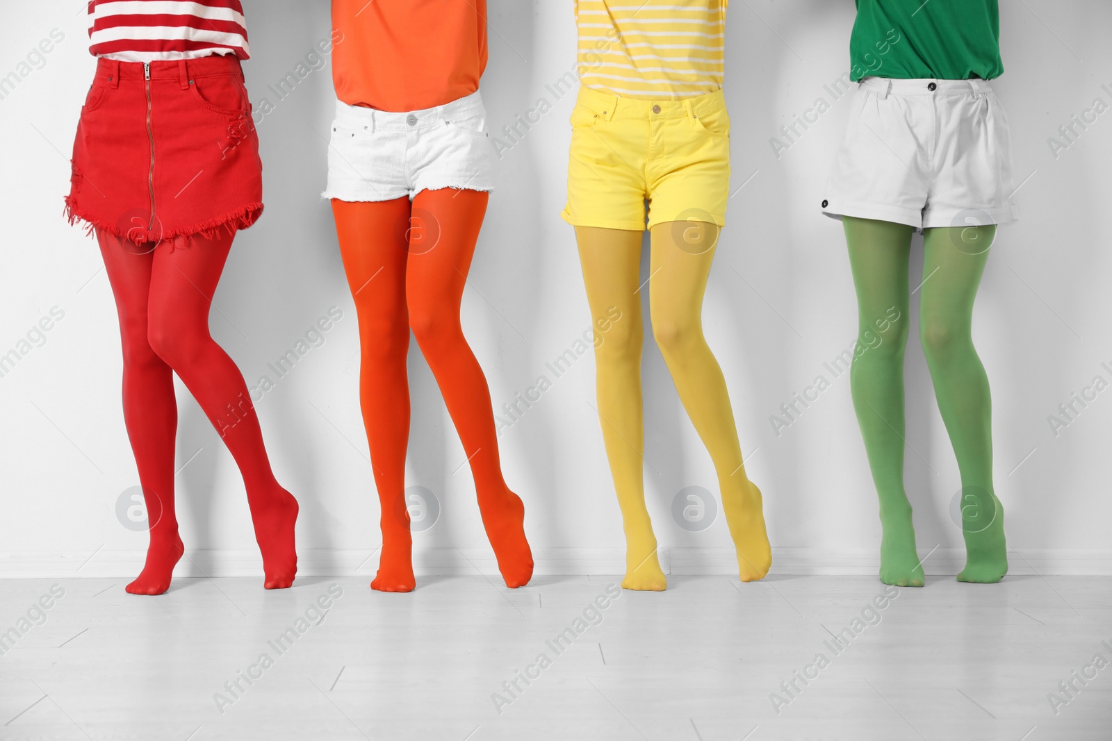 Photo of Women wearing bright tights near white wall, closeup