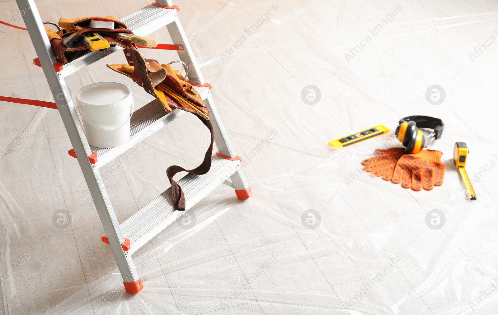 Photo of Stepladder and different tools in room. Interior renovation