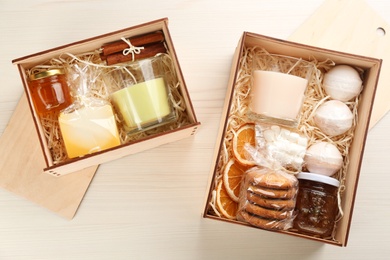 Stylish gift sets on white wooden table, flat lay