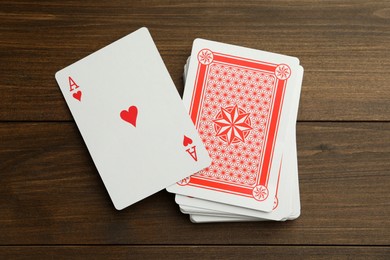 Photo of Deck of playing cards on wooden table, top view. Poker game