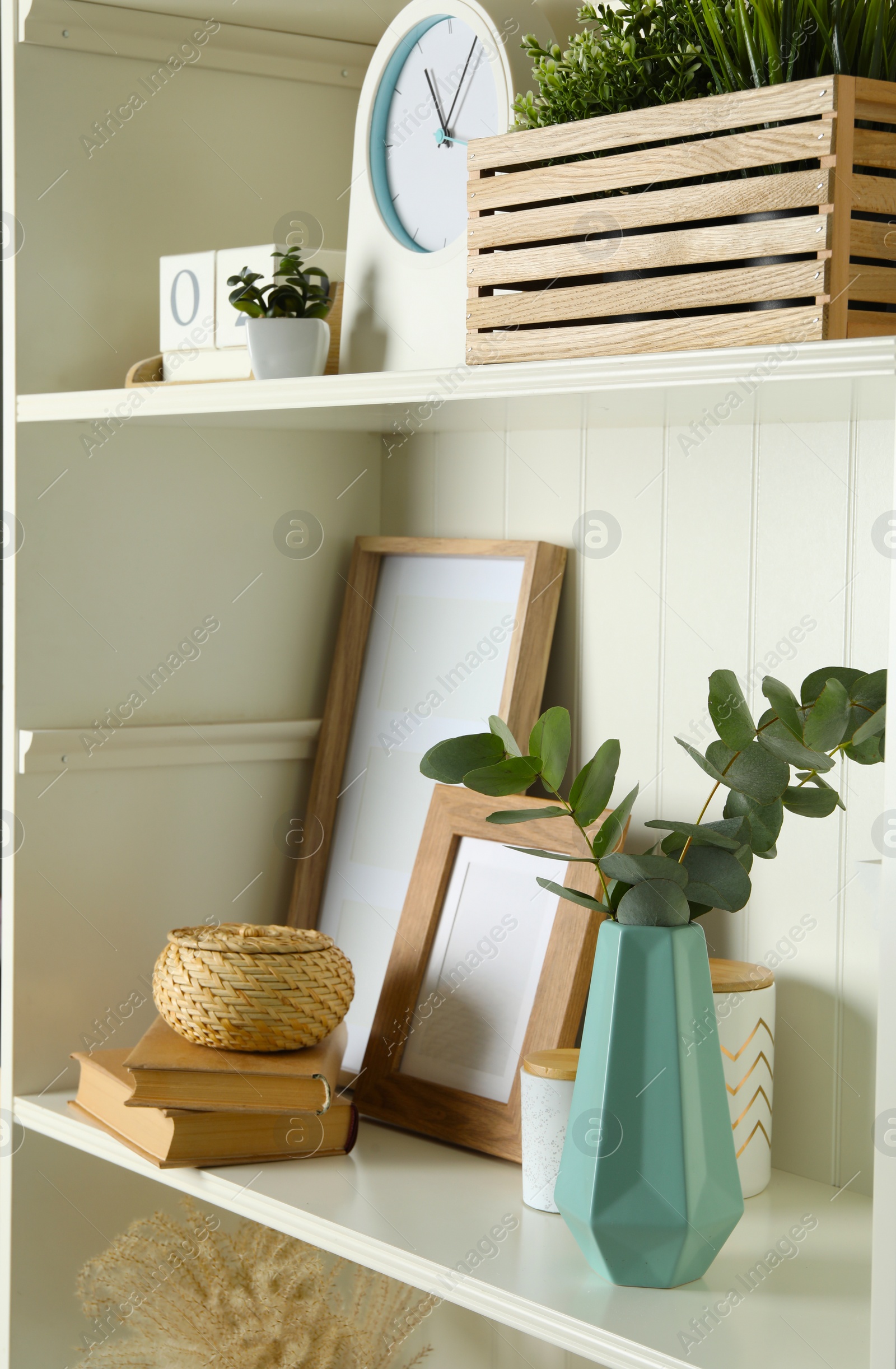 Photo of White shelving unit with different decorative elements