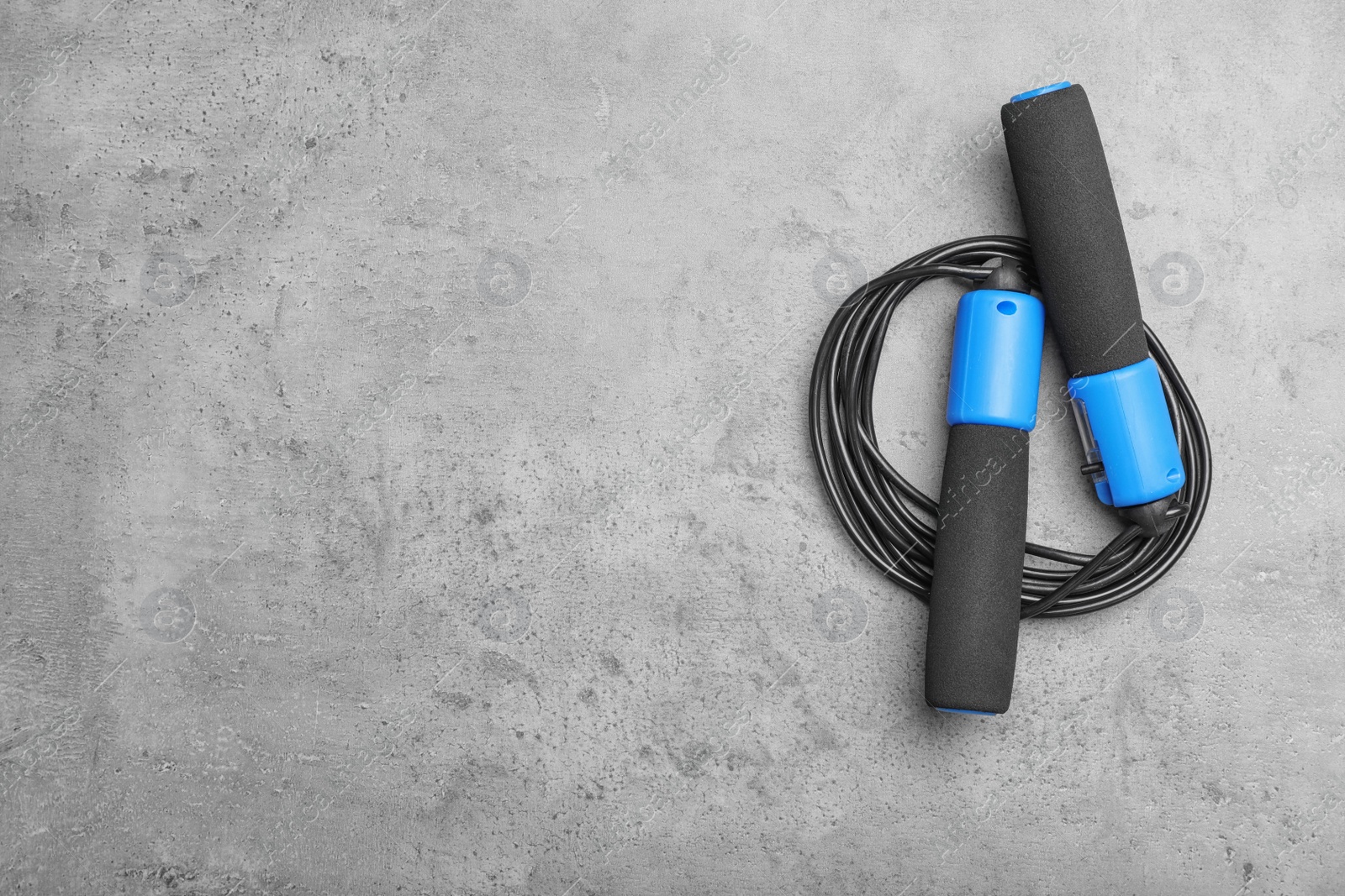 Photo of Jump rope and space for text on grey background, top view