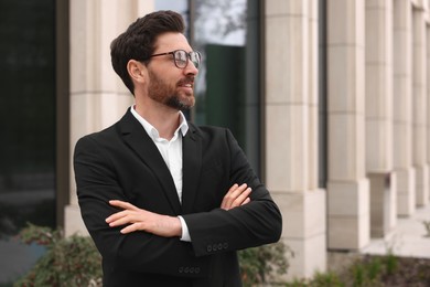 Happy real estate agent in suit outdoors. Space for text