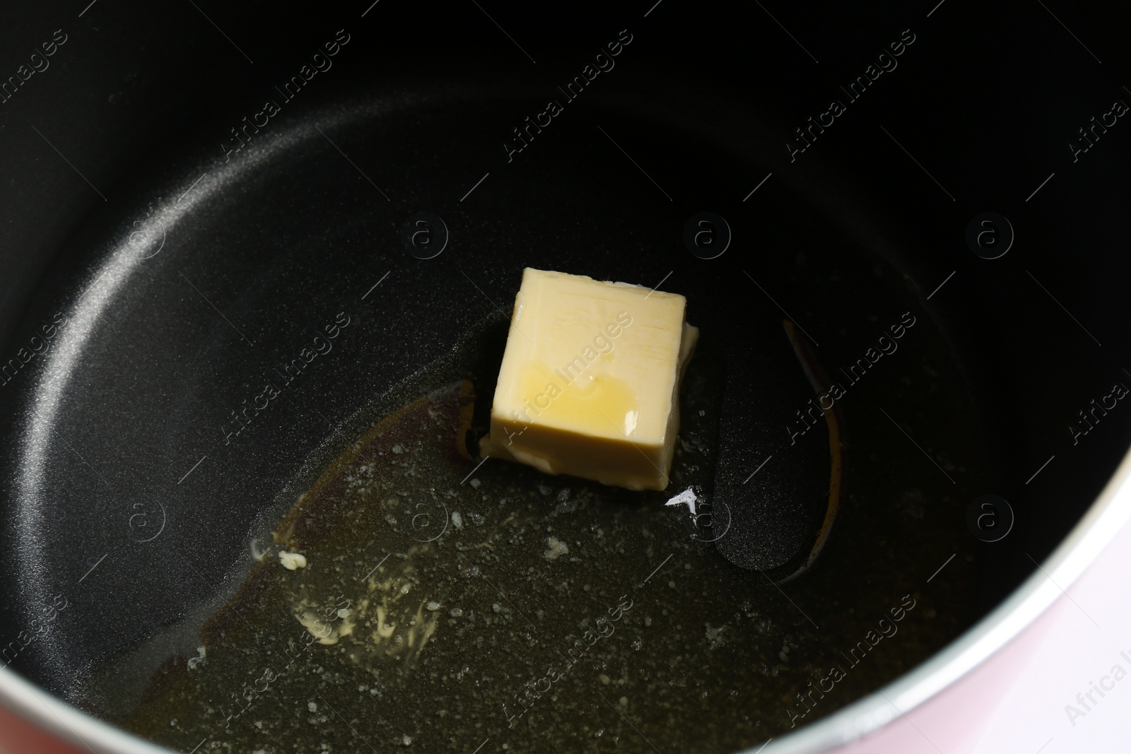 Photo of Piece of melting butter in pot, closeup