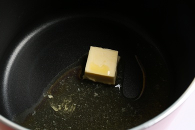 Piece of melting butter in pot, closeup