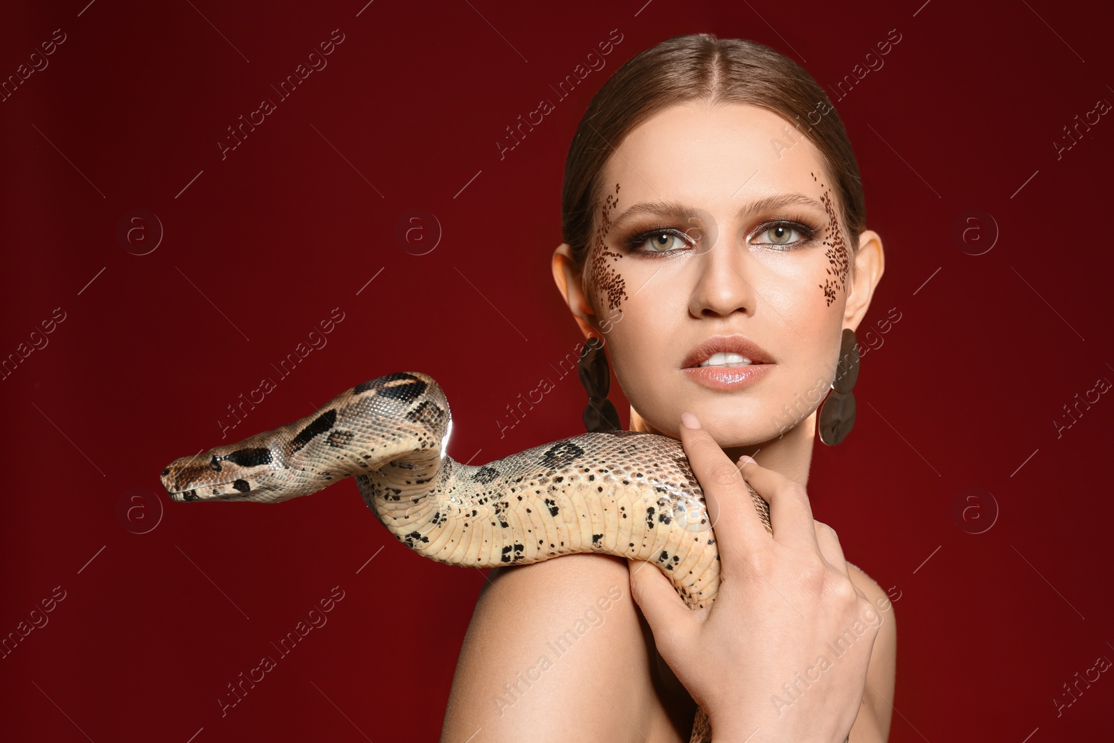 Photo of Beautiful woman with boa constrictor on bright colorful  background