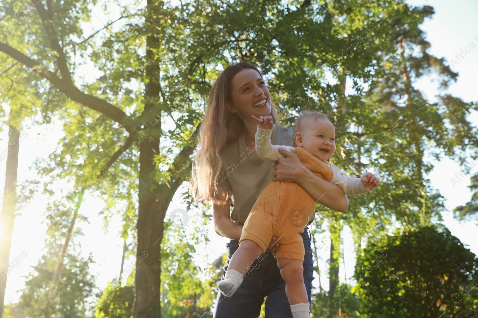 Photo of Beautiful mother with her cute daughter spending time together in park on summer day