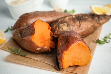 Photo of Delicious baked sweet potatoes on table, closeup