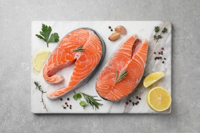 Fresh salmon and ingredients for marinade on light grey table, top view