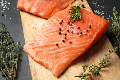 Photo of Fresh raw salmon and ingredients for marinade on black table, closeup