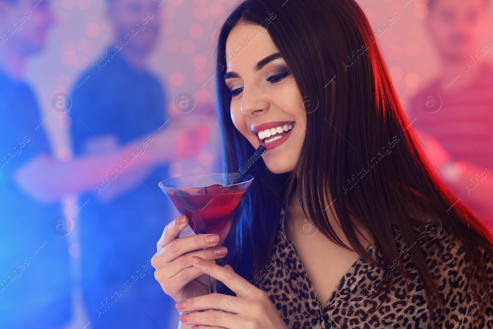 Photo of Beautiful young woman with glass of martini cocktail in bar, space for text