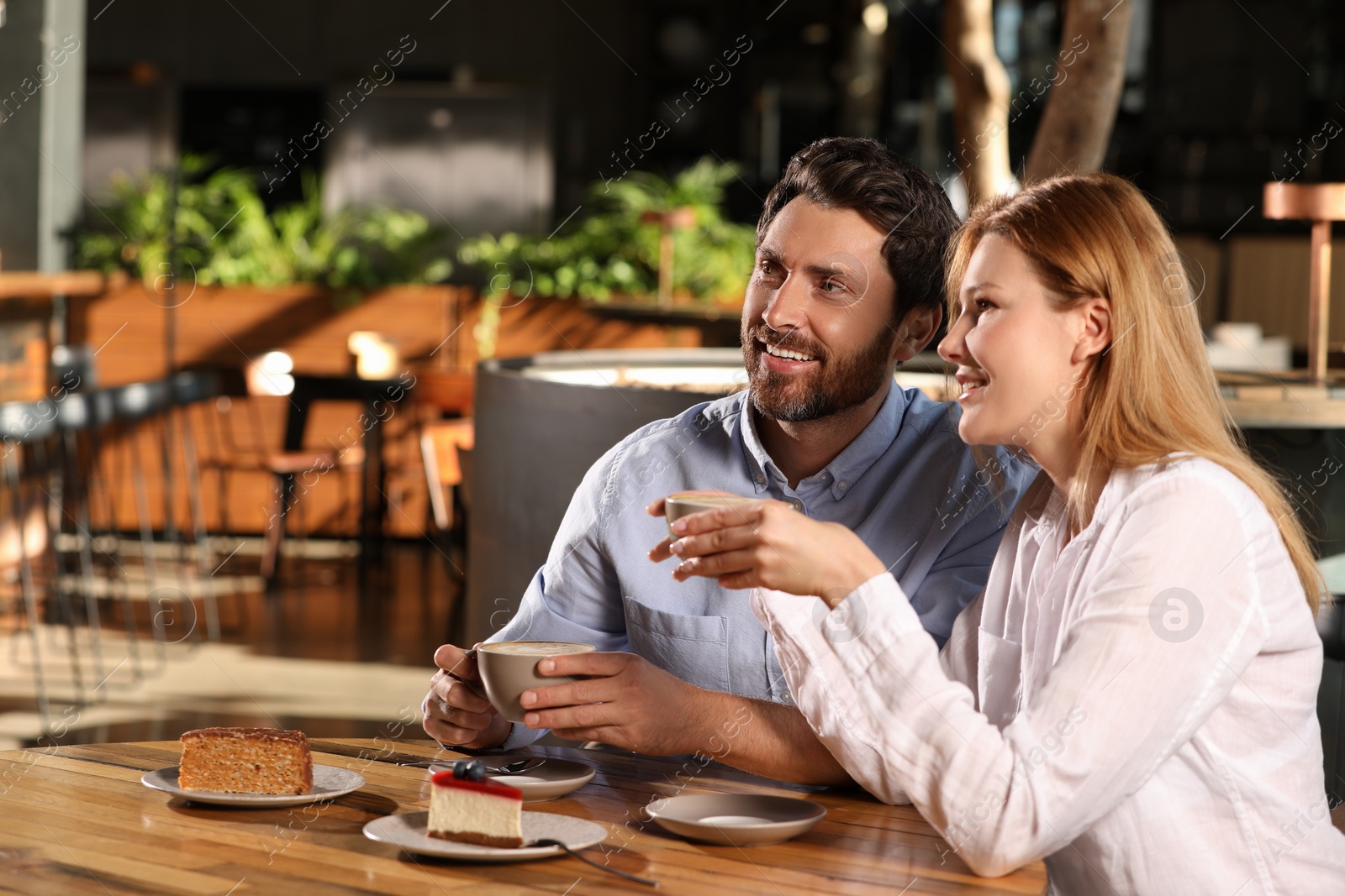 Photo of Romantic date. Lovely couple spending time together in cafe, space for text