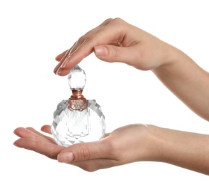 Photo of Woman holding bottle of luxury perfume on white background, closeup