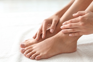 Woman with beautiful feet on white towel, closeup. Spa treatment