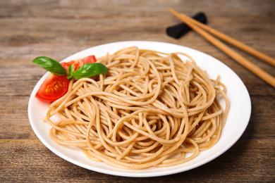 Photo of Tasty buckwheat noodles served on wooden table