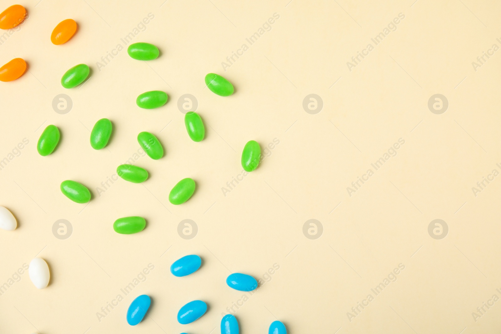Photo of Flat lay composition with jelly beans on color background. Space for text