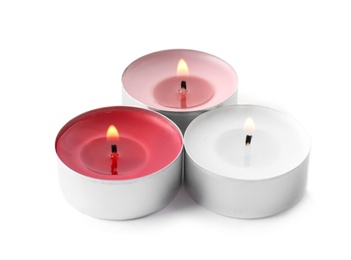 Burning decorative wax candles on white background