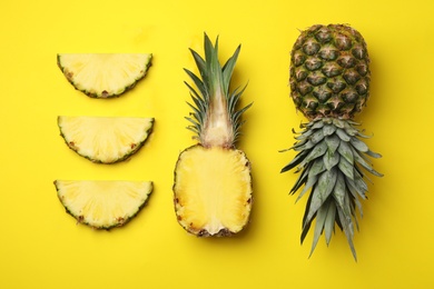 Photo of Flat lay composition with cut and fresh juicy pineapples on color background