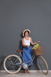 Photo of Portrait of beautiful young woman with bicycle near color wall