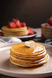 Tasty pancakes with butter and honey on plate, closeup
