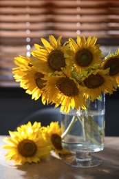 Photo of Bouquet of beautiful sunflowers on table in room