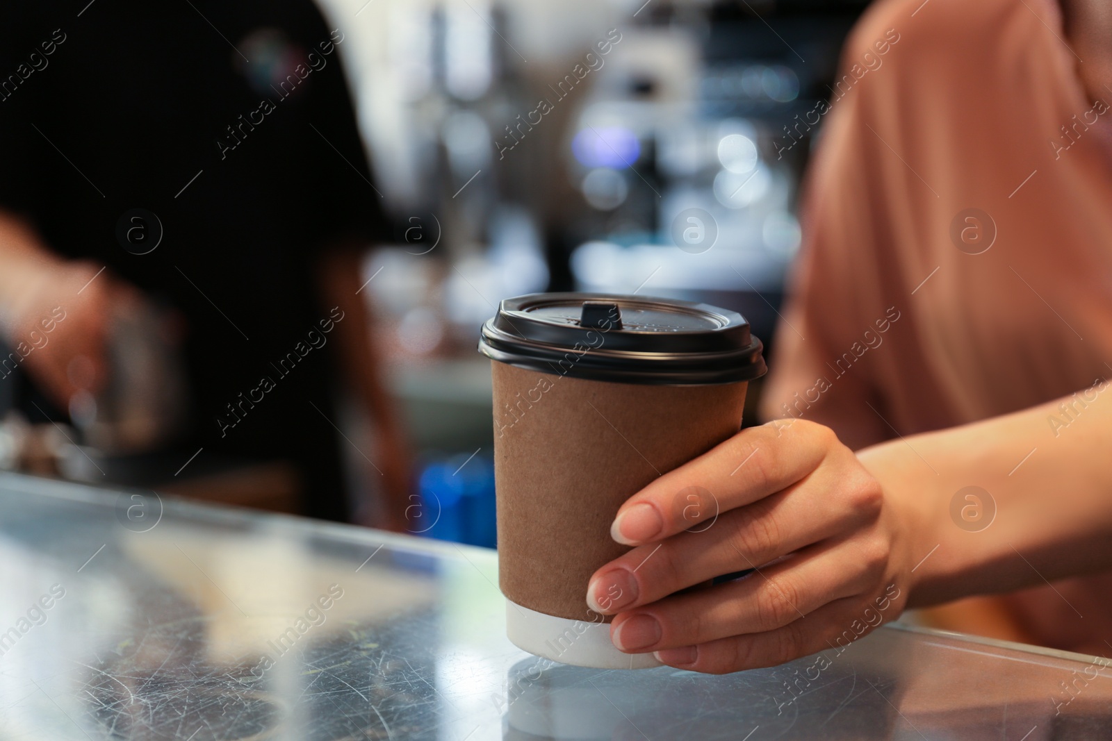 Photo of Barista putting takeaway paper cup with coffee on countertop in cafe. Space for text