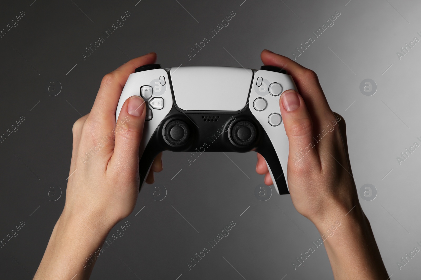 Photo of Woman using game controller on grey background, closeup