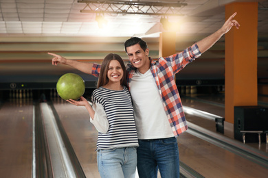 Happy couple with ball in bowling club