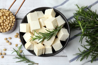 Photo of Delicious tofu cheese, rosemary and soybeans on white wooden table, flat lay