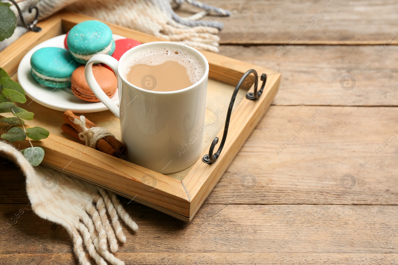 Photo of Composition with coffee and warm plaid on wooden table