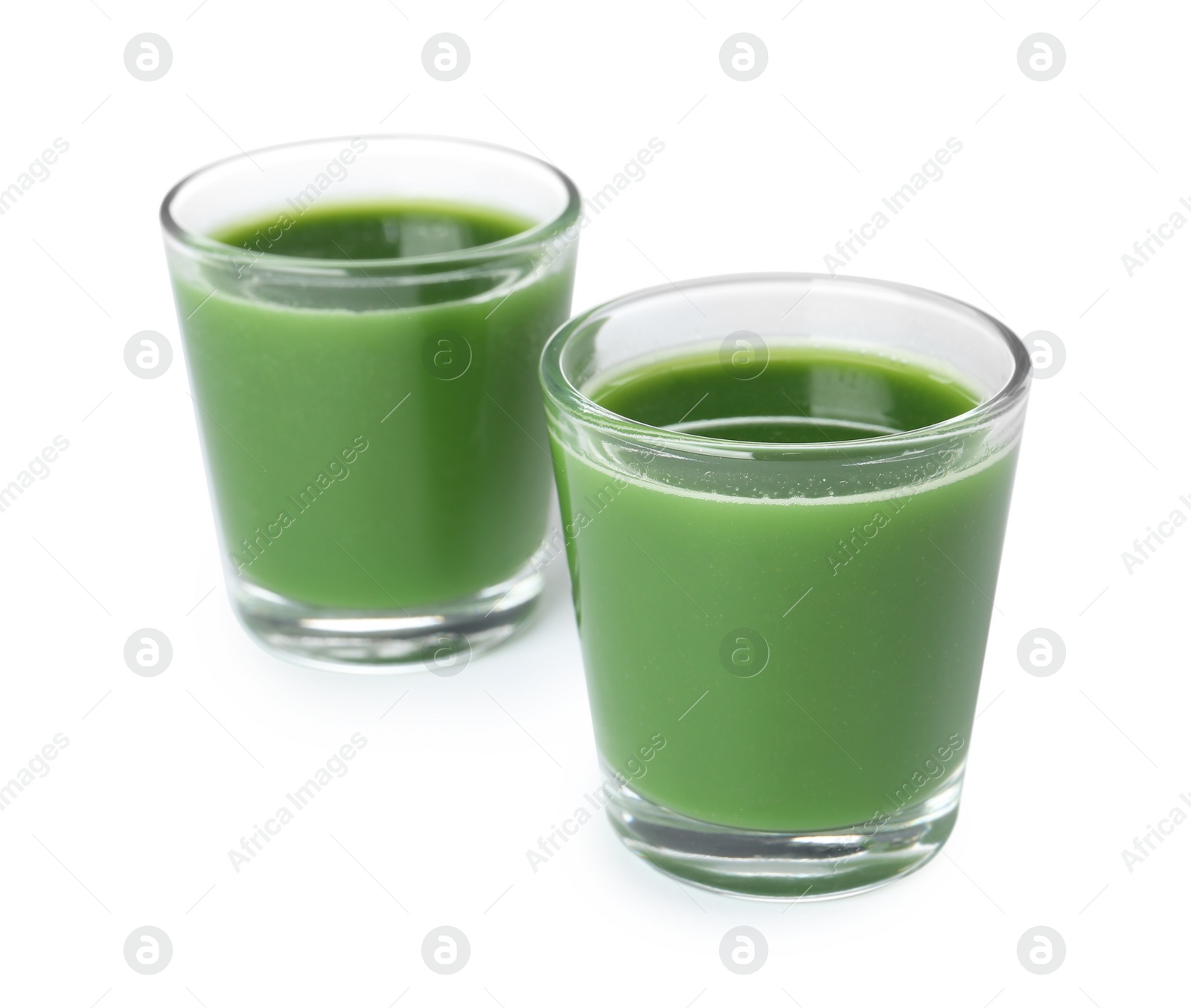 Fresh wheat grass juice in glasses on white background Photo of Fresh wheat grass juice in glasses on white background