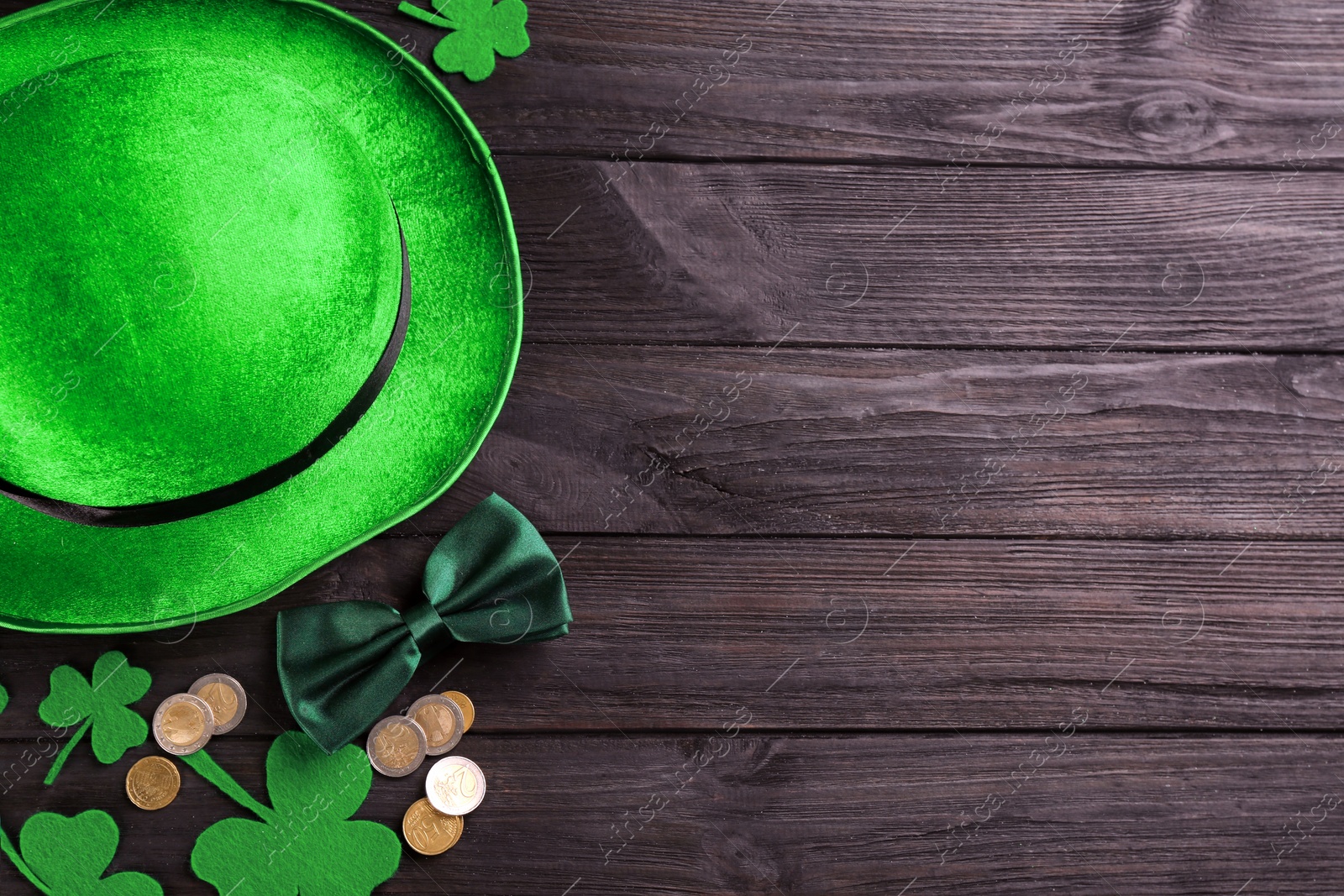 Photo of Leprechaun's hat and St. Patrick's day decor on black wooden background, flat lay. Space for text