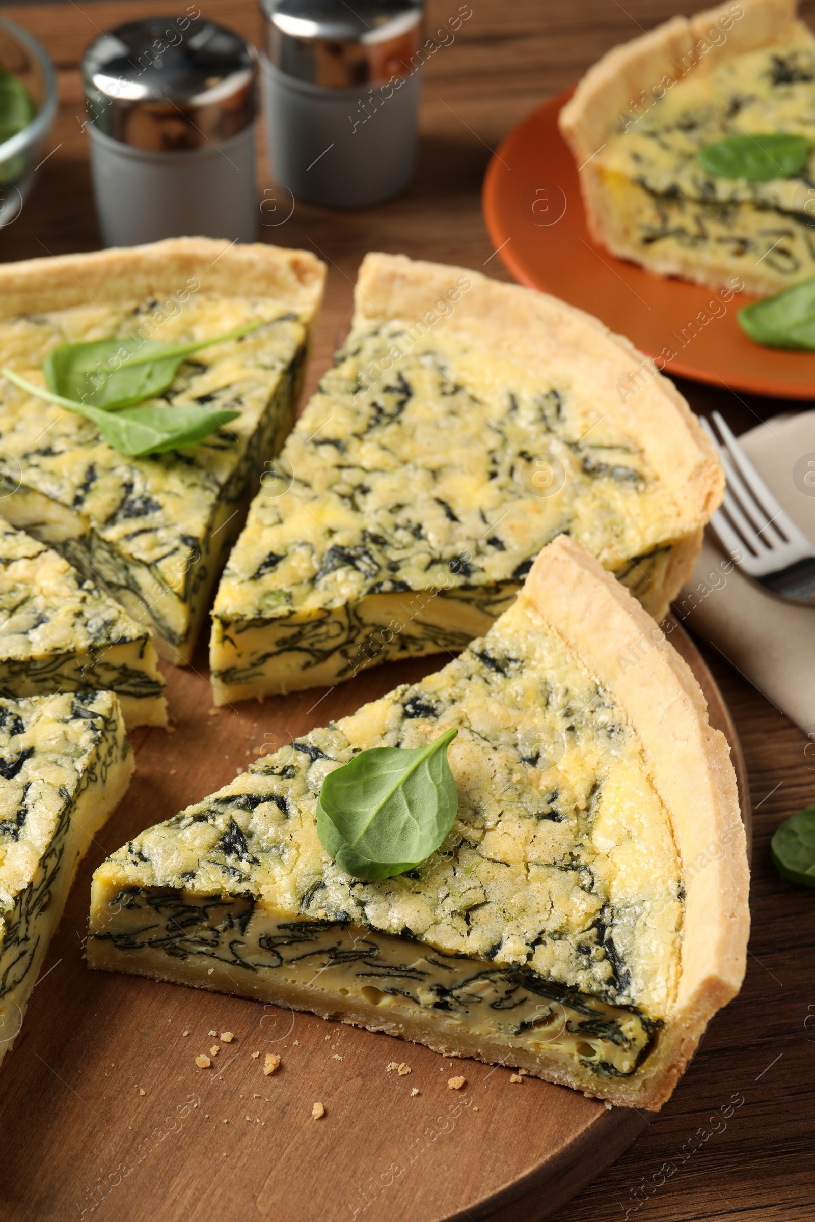 Photo of Cut delicious spinach pie on wooden board