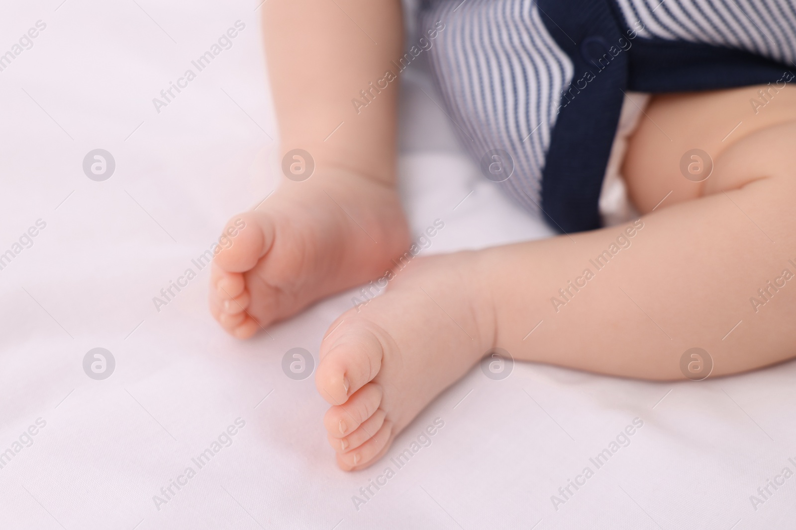 Photo of Newborn baby lying on white blanket, closeup