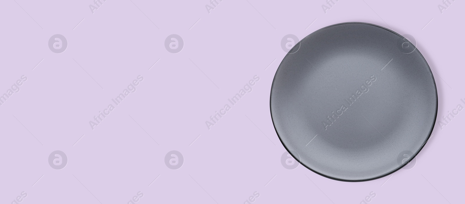 Image of Empty gray ceramic plate on violet background, top view and space for text. Banner design