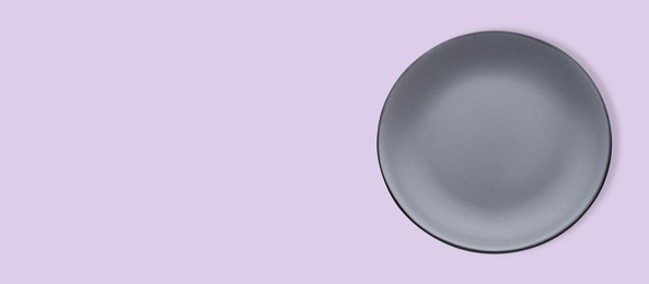 Image of Empty gray ceramic plate on violet background, top view and space for text. Banner design