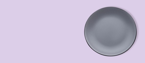 Empty gray ceramic plate on violet background, top view and space for text. Banner design