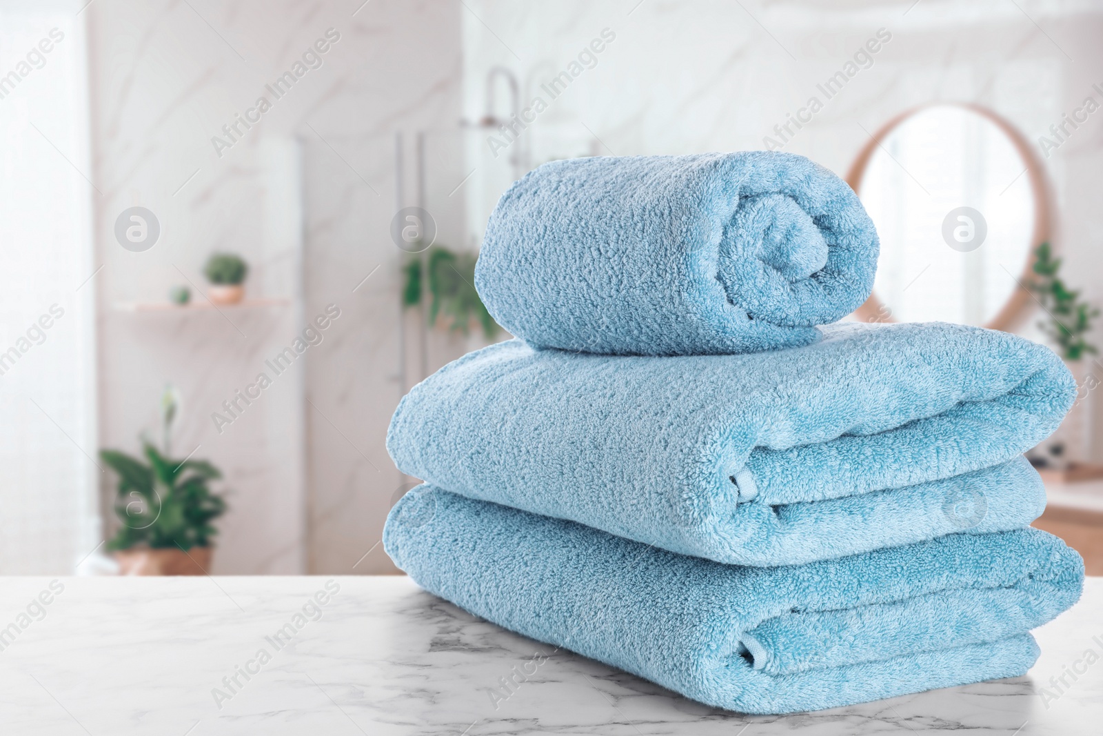 Image of Fresh towels on marble table in bathroom. Space for text