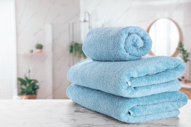 Image of Fresh towels on marble table in bathroom. Space for text