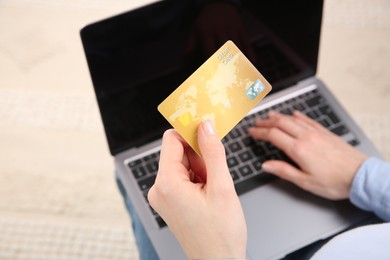 Photo of Online payment. Woman using credit card and laptop indoors, above view