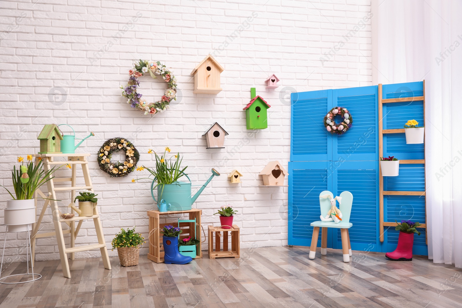 Photo of Elegant Easter photo zone with floral decor and birdhouses indoors