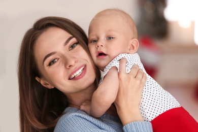 Happy mother with cute baby at home. Celebrating Christmas