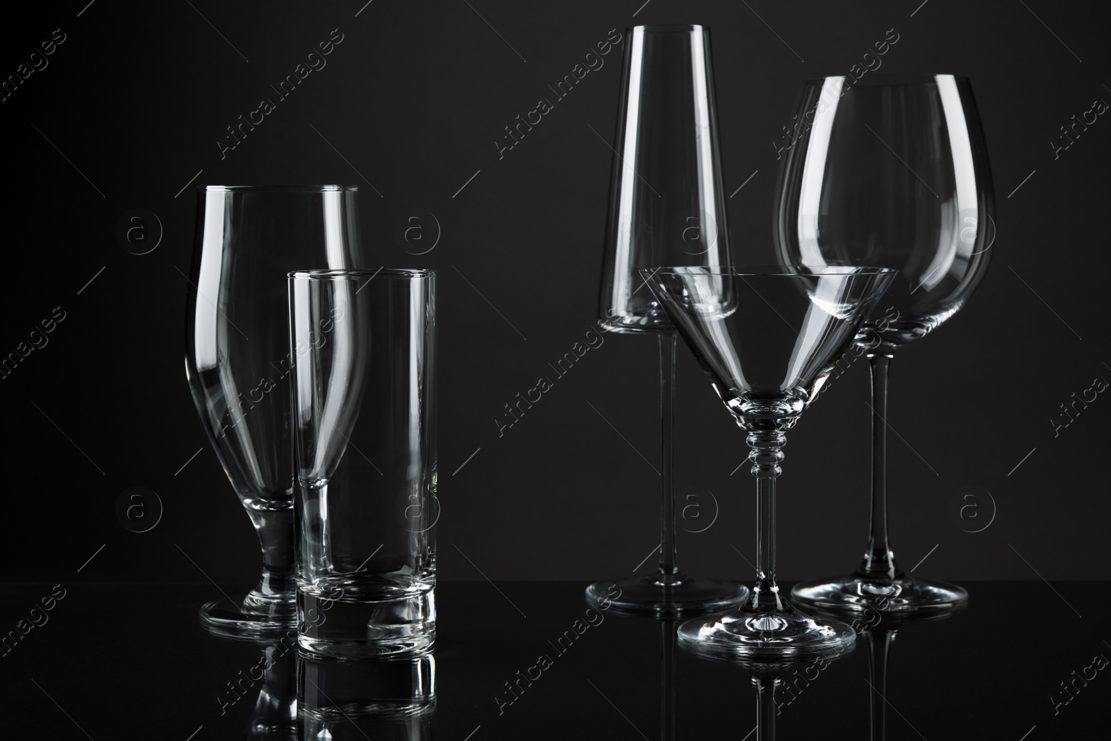 Photo of Empty glasses for different drinks on dark background