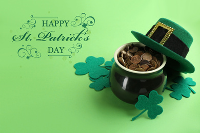 Pot with gold coins, hat and clover leaves on green background. St. Patrick's Day celebration