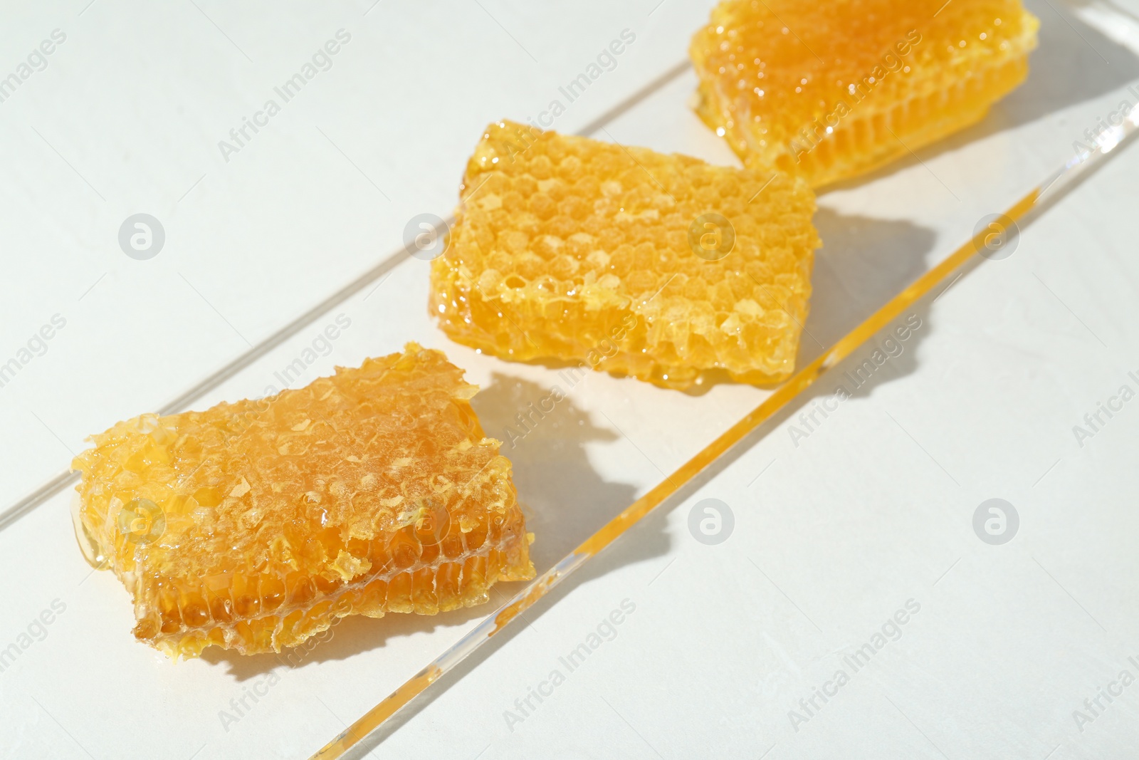 Photo of Natural honeycombs with tasty honey on white table